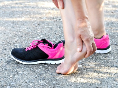 runner holding heel. Heel pain treatment Leeds